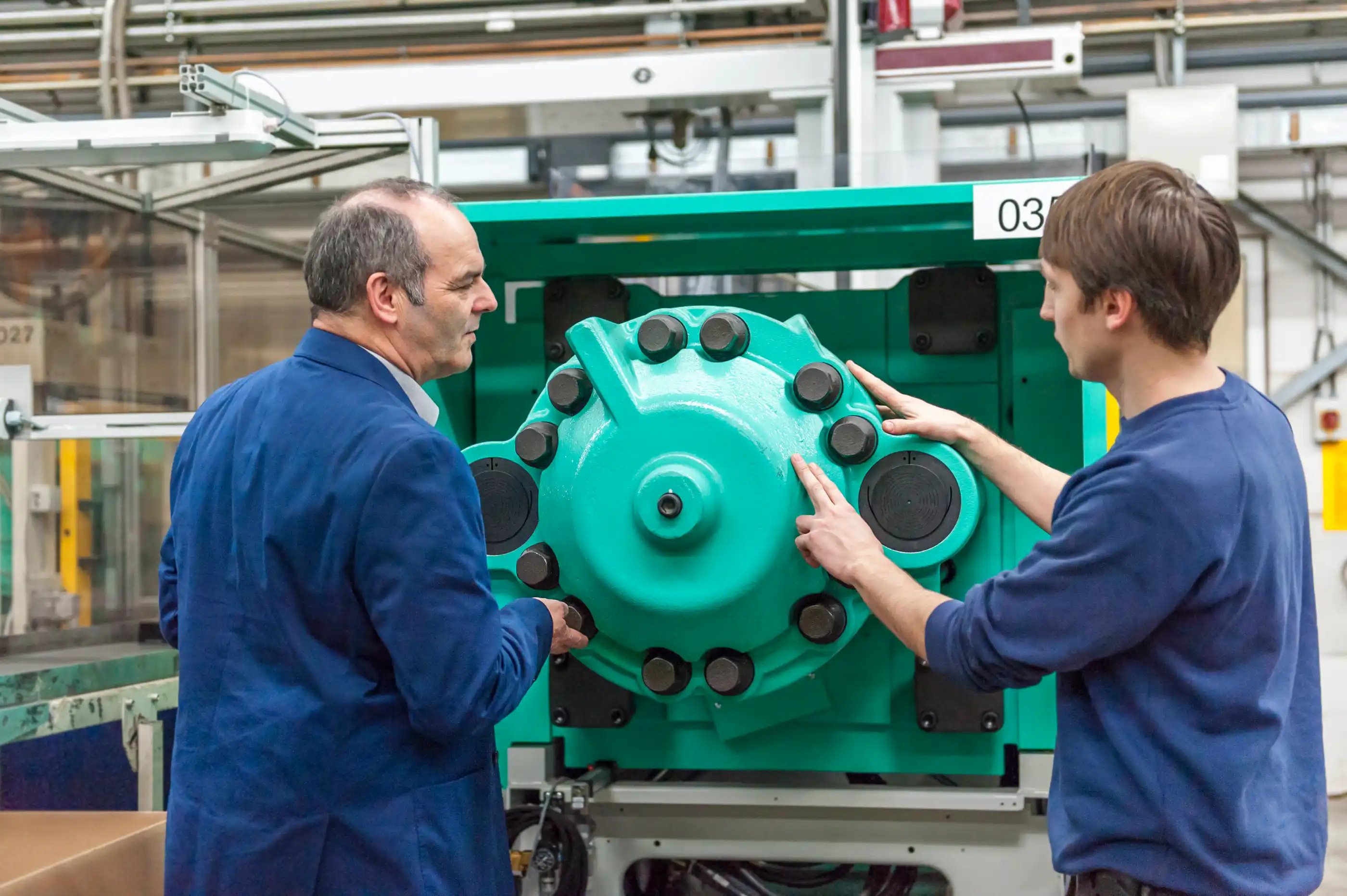 two-people-in-plastics-factory-examining-machines-2024-09-22-16-19-17-utc